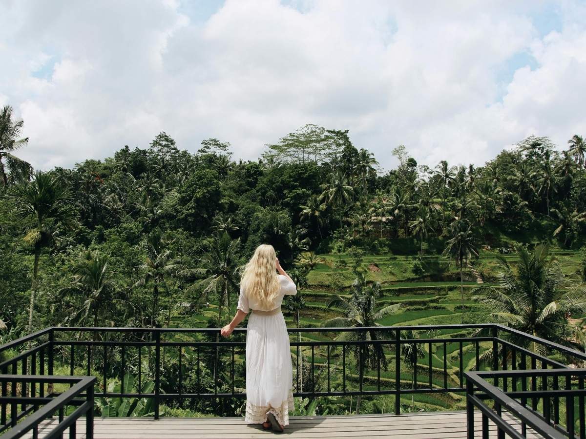 Back View of Blonde Woman on a Terrace Looking at Green Tropical Forest